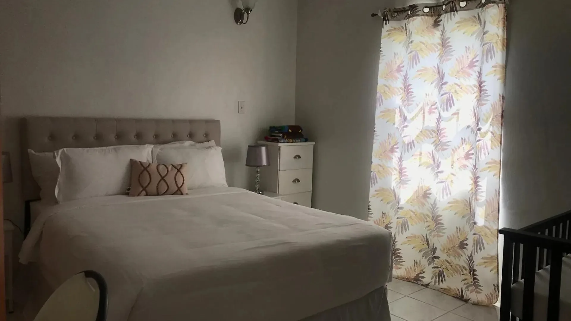 Downstairs Ensuite guest room with queen bed and crib at Compassionate Touch B&B